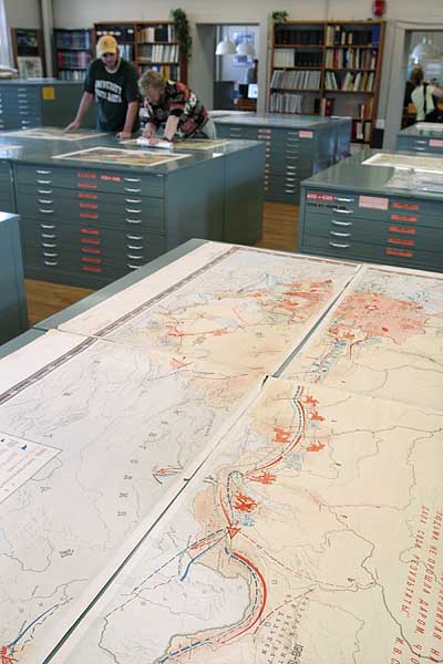 Library assistants help users find maps in the library
